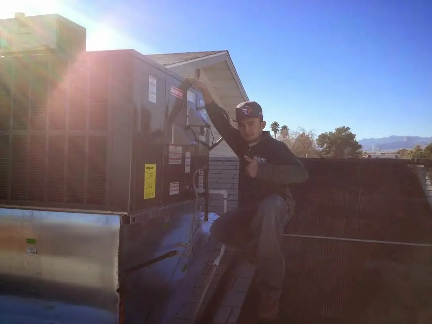 HVAC technician performing Air Duct Cleaning on a rooftop unit in La Riviera